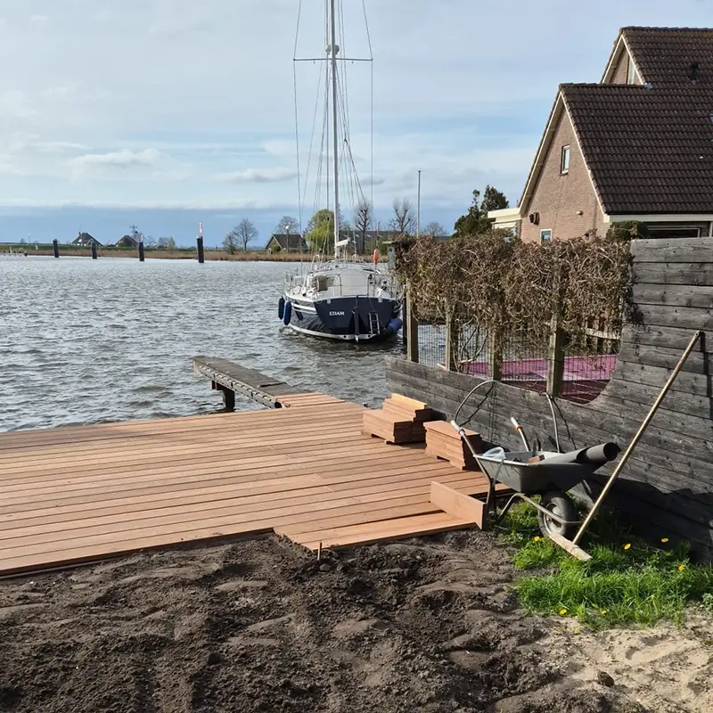 Aanlegsteigers met zeilboot op de achtergrond